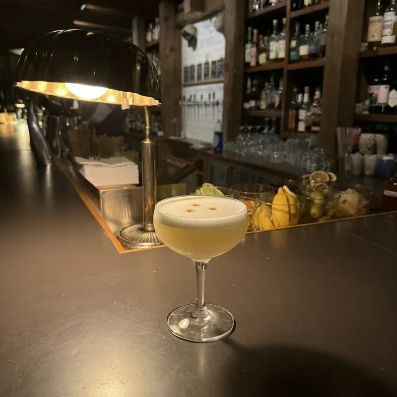The Pisco Sour cocktail, dim candlelight at Robin Room.